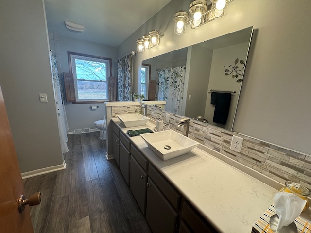 full bath featuring wood finished floors, toilet, baseboards, and a sink