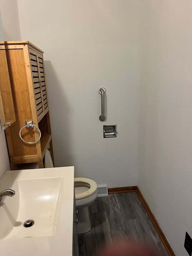 bathroom featuring hardwood / wood-style floors, toilet, and sink