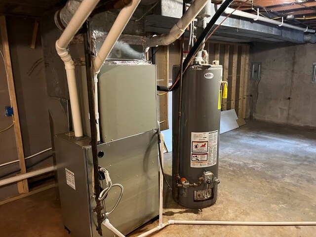 utility room featuring heating unit and water heater