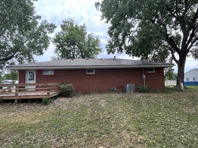 back of house featuring a lawn, central AC, and a deck