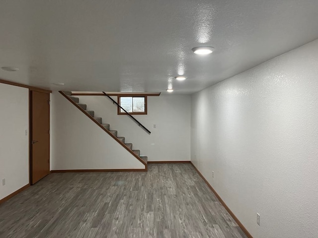 basement featuring hardwood / wood-style floors and a textured ceiling