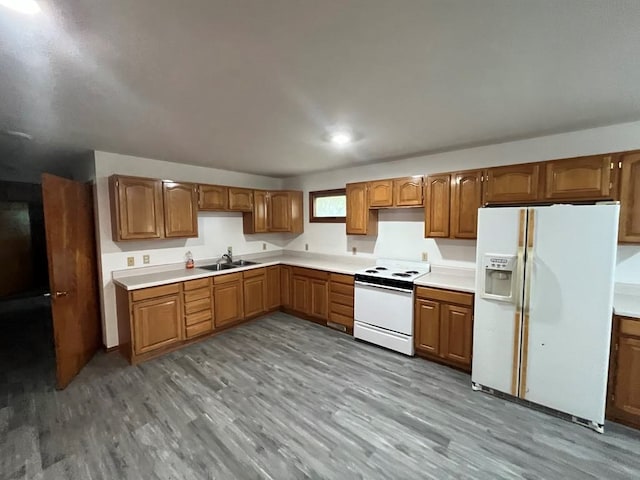 kitchen featuring light wood-type flooring, white appliances, and sink