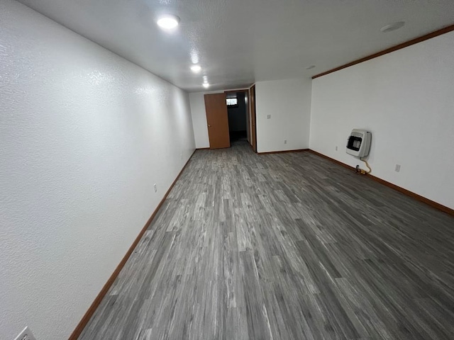 spare room with dark hardwood / wood-style floors and heating unit