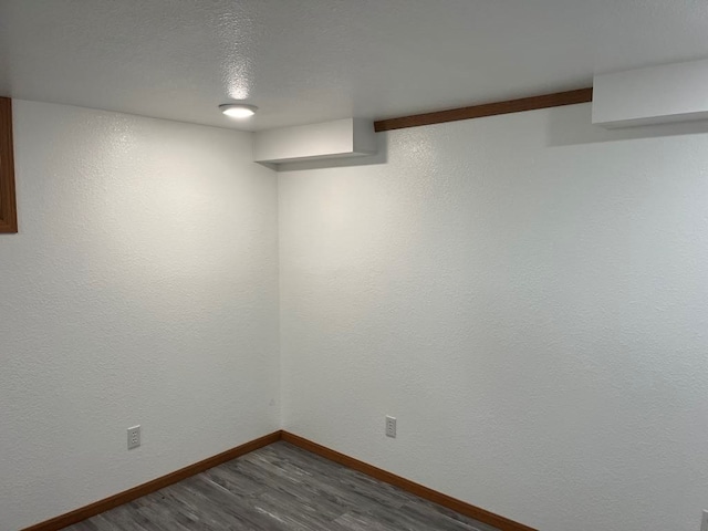 spare room featuring dark hardwood / wood-style flooring and a textured ceiling