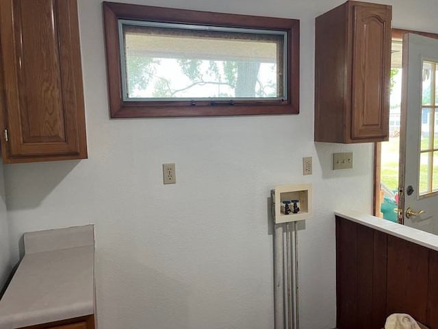 laundry room featuring washer hookup, a healthy amount of sunlight, and cabinets