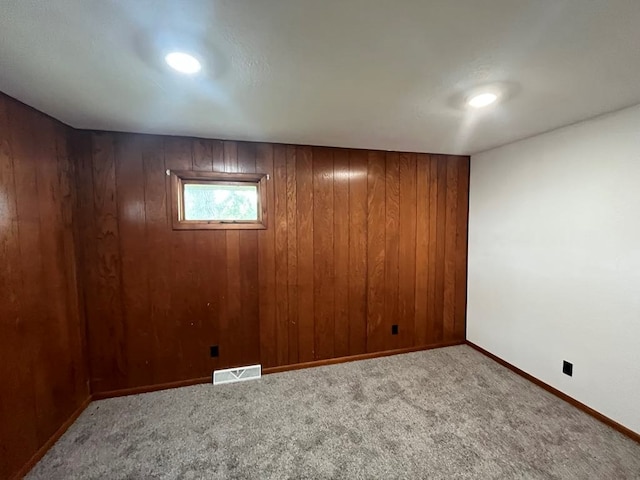 basement featuring carpet and wood walls