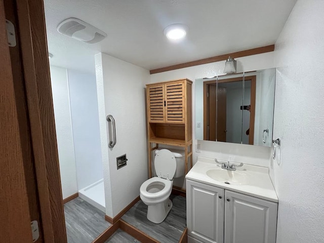 bathroom with hardwood / wood-style flooring, vanity, toilet, and a shower