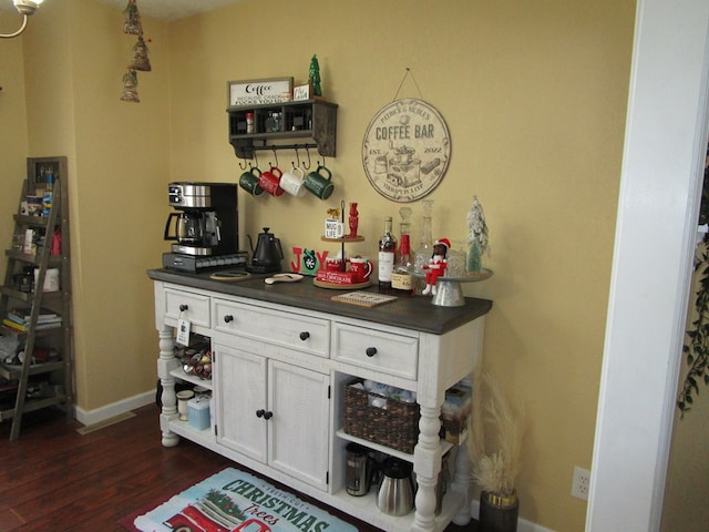 bar with white cabinets and dark hardwood / wood-style floors