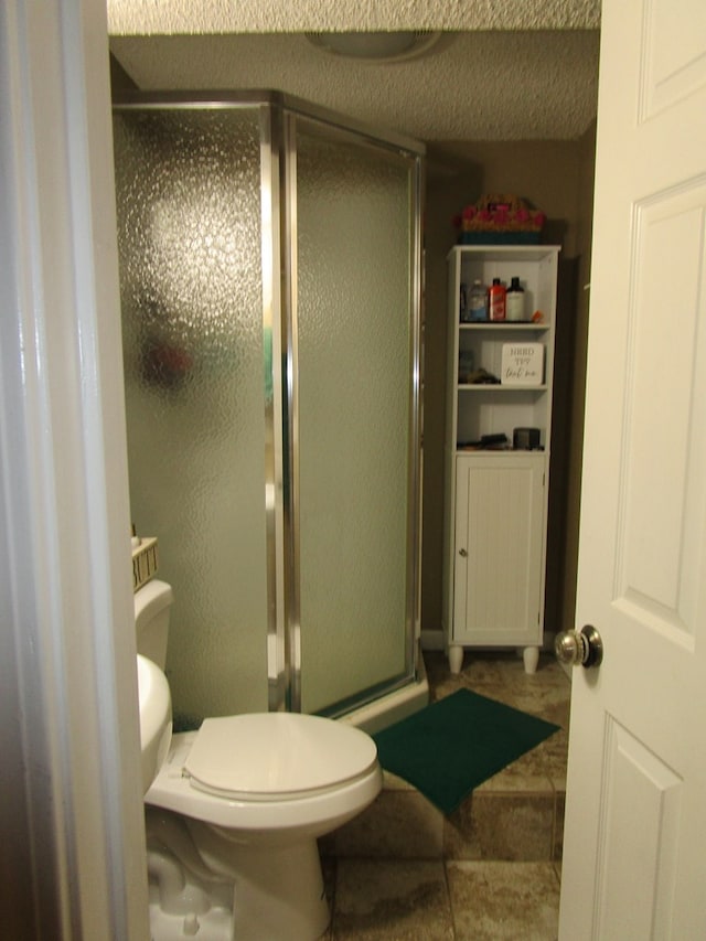 bathroom with a shower with shower door and toilet