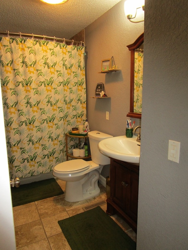 bathroom featuring vanity, tile patterned floors, toilet, a textured ceiling, and curtained shower