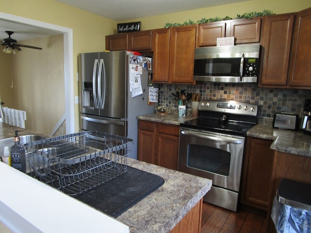 kitchen with backsplash, stainless steel appliances, dark hardwood / wood-style floors, and ceiling fan