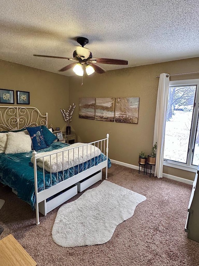 carpeted bedroom with ceiling fan and a textured ceiling