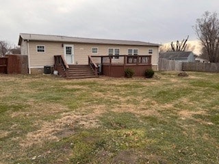 back of house featuring a lawn and a deck