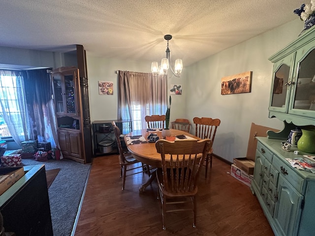 dining room featuring a textured ceiling, dark hardwood / wood-style flooring, and a notable chandelier