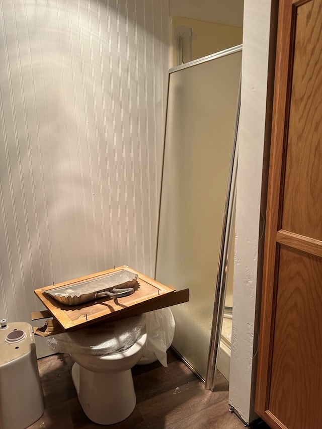 bathroom with wood-type flooring and a shower with shower door