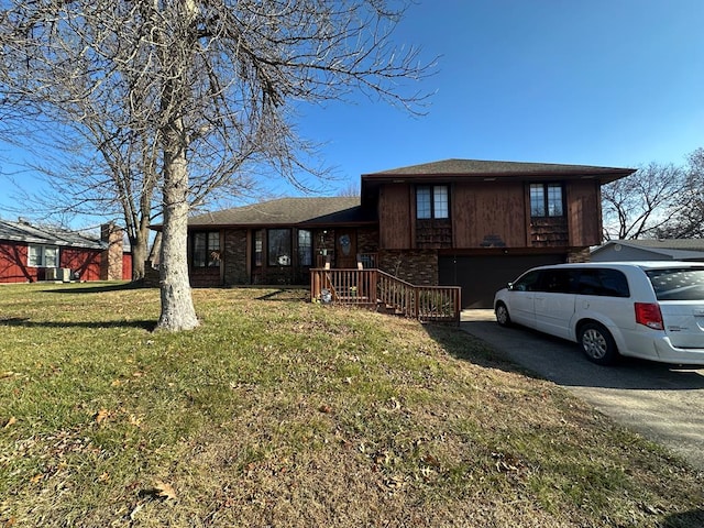 split level home featuring a garage and a front lawn