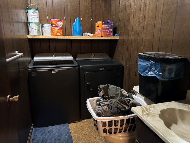 laundry area with wood walls and independent washer and dryer