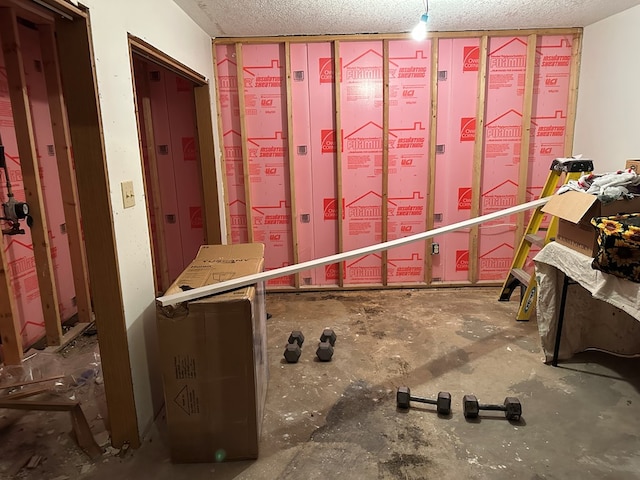 miscellaneous room featuring concrete flooring and a textured ceiling