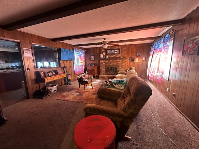 living room featuring beam ceiling, ceiling fan, a brick fireplace, wood walls, and carpet floors