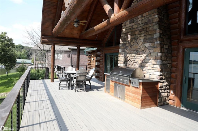 deck featuring a grill, an outdoor kitchen, and outdoor dining space