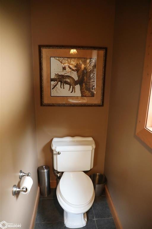 bathroom featuring toilet, baseboards, and tile patterned floors