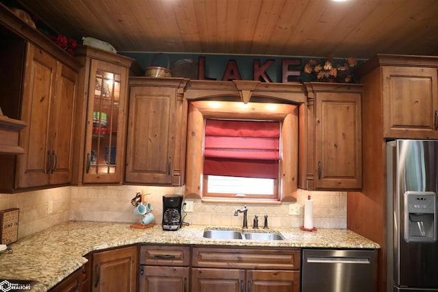 kitchen featuring wood ceiling, appliances with stainless steel finishes, brown cabinetry, and a sink