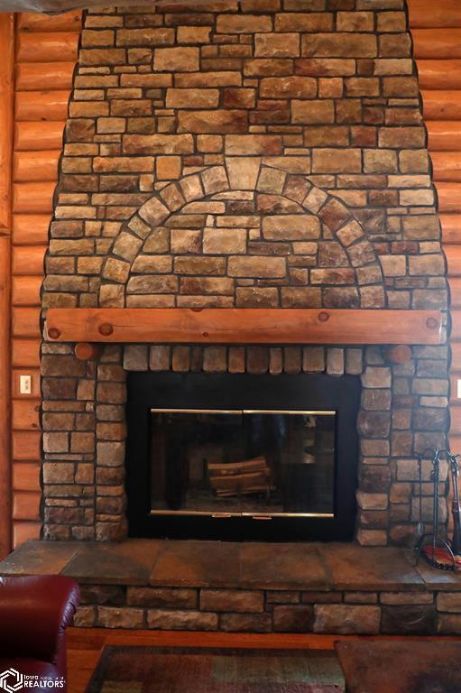 interior details with a fireplace and log walls