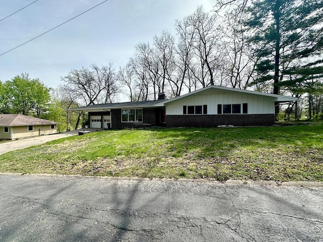 view of front facade featuring a garage, a front lawn, and a carport