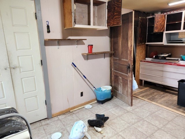 605 High St, Linneus, MO 64653 - kitchen featuring light floors, open shelves, white cabinets, and wooden walls