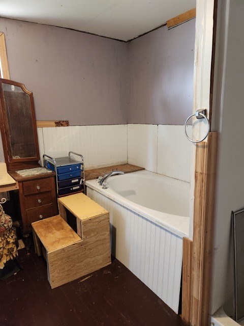 605 High St, Linneus, MO 64653 - bathroom featuring a bath, wood finished floors, and wainscoting