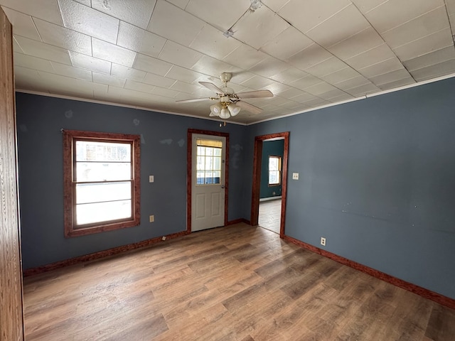 spare room with ceiling fan, wood-type flooring, and ornamental molding