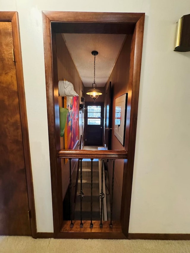 hall with a textured ceiling and carpet floors