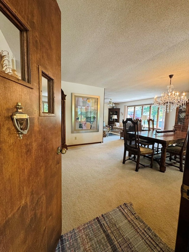 dining room featuring a textured ceiling, carpet floors, and ceiling fan with notable chandelier