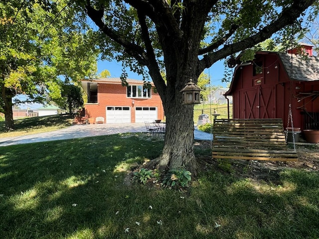 view of side of property featuring a lawn, an outdoor structure, and a garage