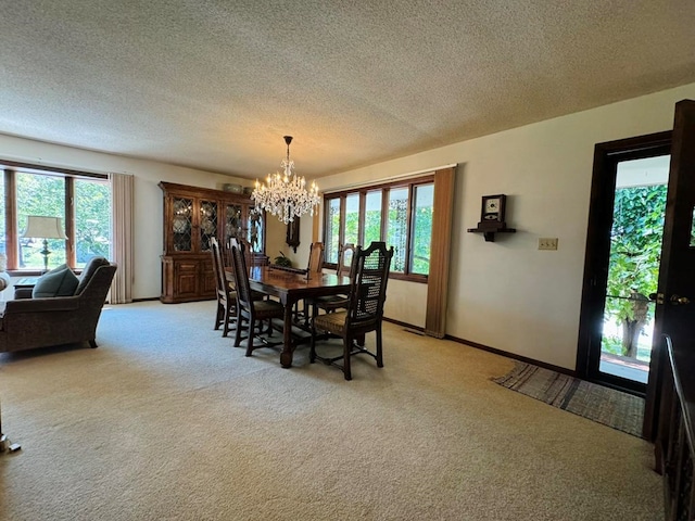 carpeted dining area featuring a textured ceiling and a notable chandelier