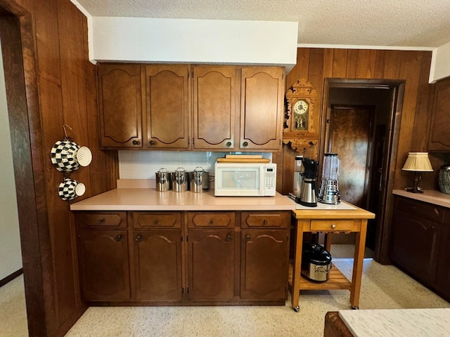 kitchen with a textured ceiling and wooden walls