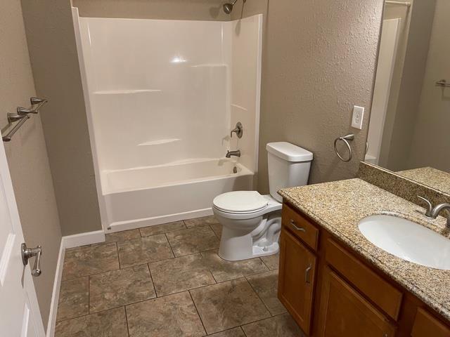 full bathroom featuring toilet, vanity, and bathing tub / shower combination