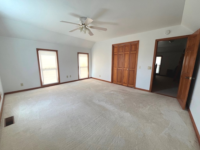 unfurnished bedroom with light carpet, vaulted ceiling, and ceiling fan