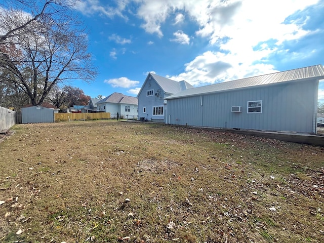 rear view of property with a lawn and a storage shed