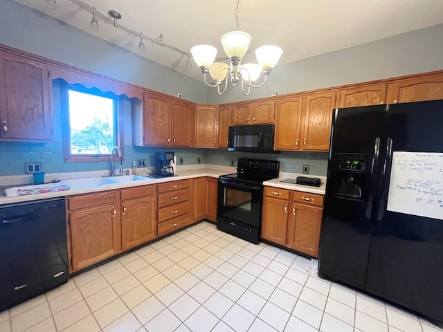 kitchen with sink, hanging light fixtures, a chandelier, light tile patterned floors, and black appliances