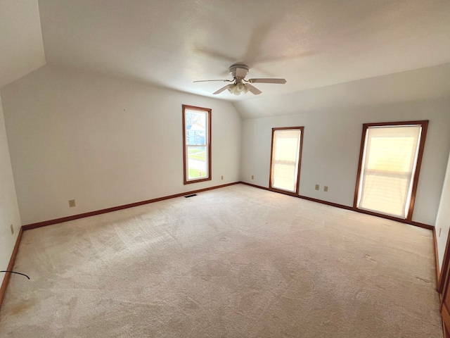 carpeted empty room featuring vaulted ceiling and ceiling fan