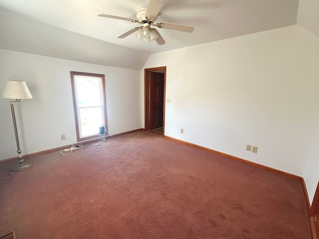 carpeted spare room featuring ceiling fan and lofted ceiling