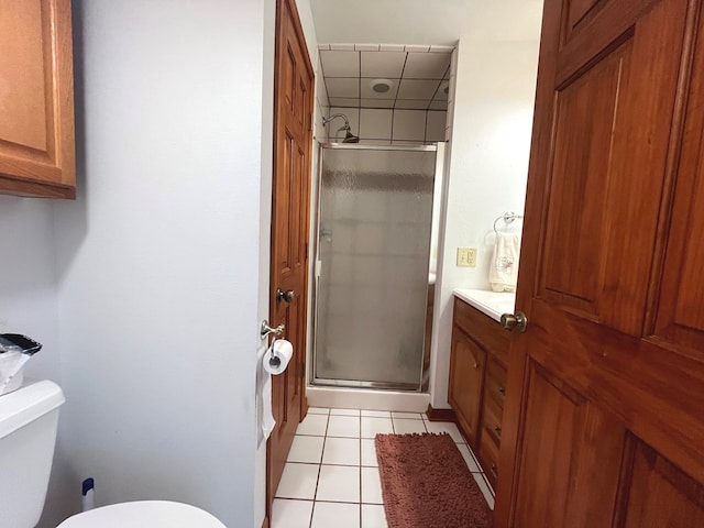 bathroom featuring tile patterned floors, a shower with door, vanity, and toilet