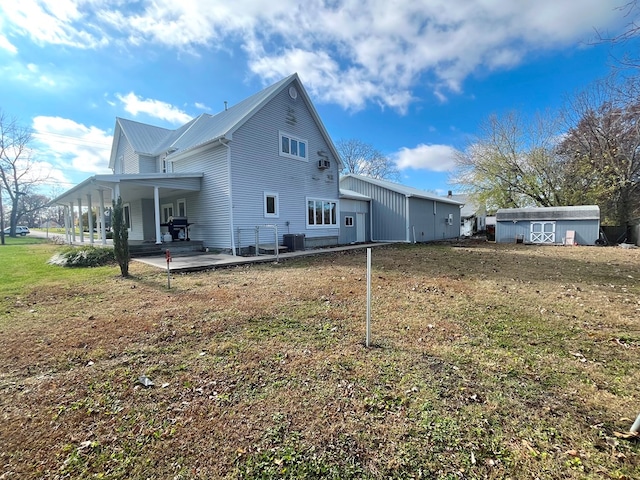 rear view of property with a yard and a storage shed