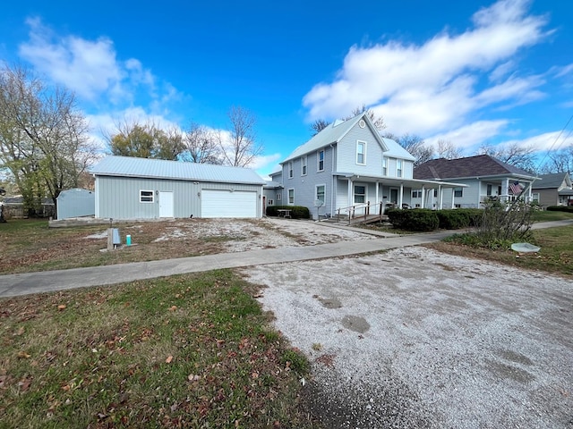 view of front of property with covered porch, a garage, and an outdoor structure