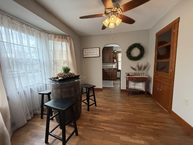 1316 Porter, Kirksville, MO 63501 - dining space featuring ceiling fan, baseboards, arched walkways, and dark wood finished floors