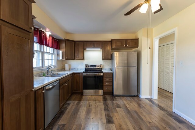 500 W Santa Fe St, Marceline, MO 64658 - kitchen with appliances with stainless steel finishes, light stone counters, ceiling fan, sink, and dark hardwood / wood-style floors