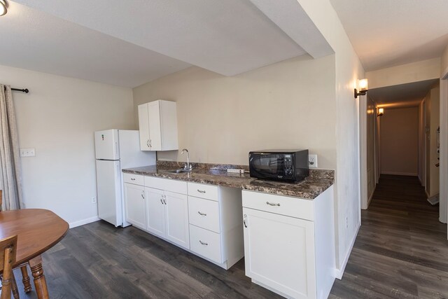 500 W Santa Fe St, Marceline, MO 64658 - kitchen featuring white cabinets, white fridge, dark hardwood / wood-style flooring, and sink