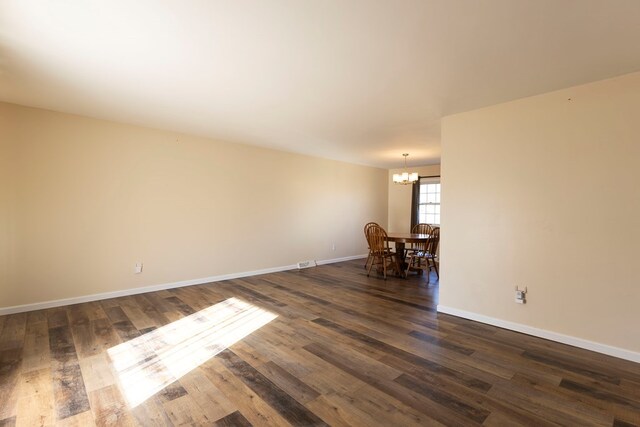 500 W Santa Fe St, Marceline, MO 64658 - spare room with a notable chandelier and dark hardwood / wood-style floors