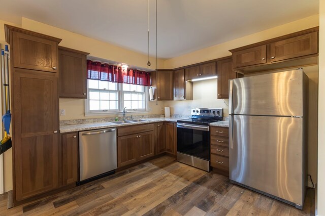 500 W Santa Fe St, Marceline, MO 64658 - kitchen featuring light stone countertops, appliances with stainless steel finishes, dark hardwood / wood-style flooring, and sink